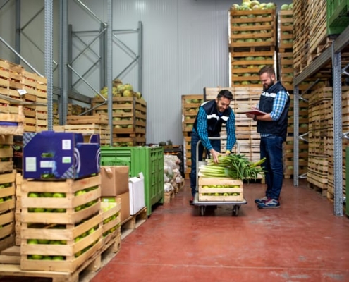 Workers unload produce in a distribution center