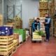 Workers unload produce in a distribution center