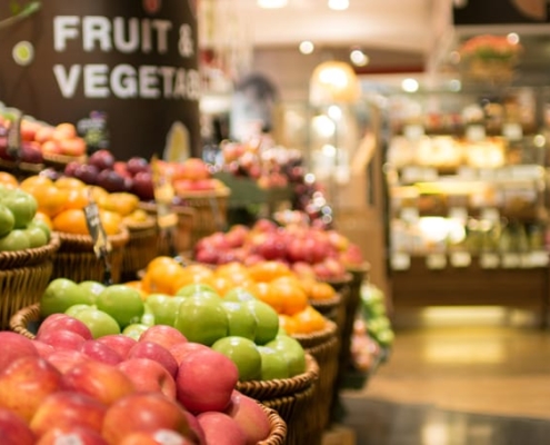 A display of oranges and red and green apples in the produce department of a grocery store