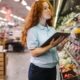 A produce department employee visually inspects fresh produce