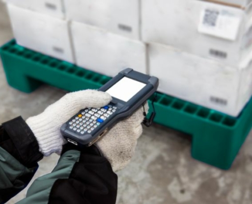 An employee scans a pallet of fruit in a distribution center