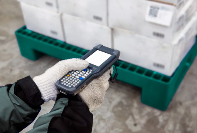 An employee scans a pallet of fruit in a distribution center