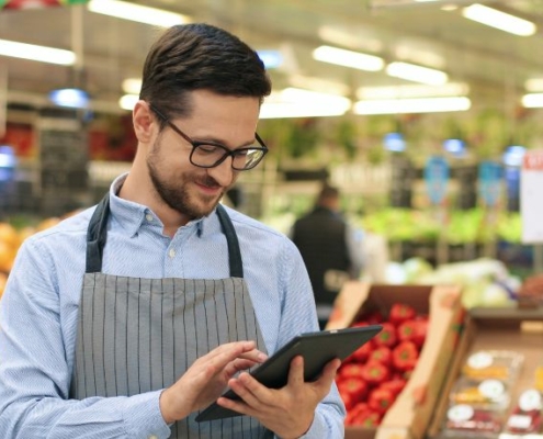 A grocery store employee using a tablet