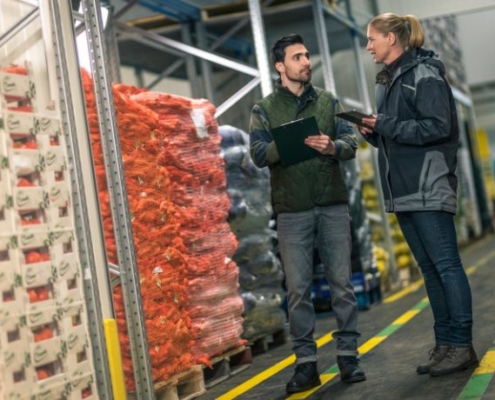 Two inspectors discuss a quality inspection in a distribution center