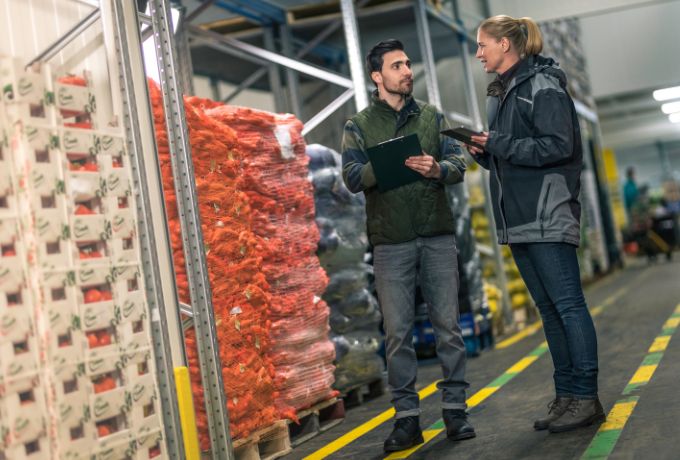 Two inspectors discuss a quality inspection in a distribution center