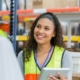 A woman working in a produce distribution center uses a tablet to perform a quality inspection