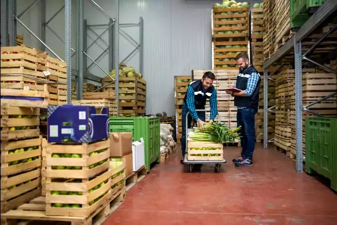 Workers unload produce in a distribution center