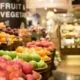 A display of oranges and red and green apples in the produce department of a grocery store